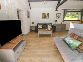A living room with a sofa and television at Daffodil Cottage near Blaencwm