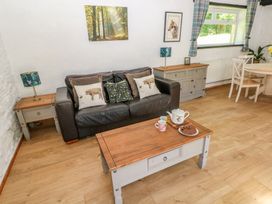 A living room with a sofa and coffee table at Daffodil Cottage in Blaencwm near Treorchy