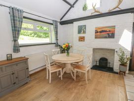 A dining room with a table and chairs at Daffodil Cottage in Blaencwm near Treorchy