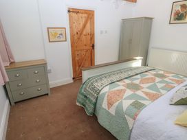 A bedroom with a bed and furniture at Daffodil Cottage in Blaencwm near Treorchy