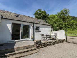 An outdoor seating area with a table and chairs at Daffodil Cottage in Blaencwm near Treorchy