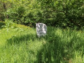 A stone sign marking Dingley Dell in a wooded area