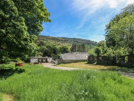 A house surrounded by trees and grass at Daffodil Cottage in Blaencwm near Treorchy