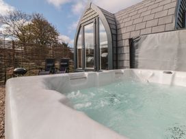 An outdoor area with a hot tub and chairs at Cosy Cocoon in Malton