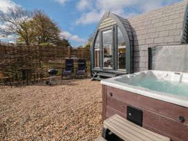 An outdoor area with a hot tub and chairs at Cosy Cocoon in Malton