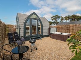 An outdoor area with a hot tub and seating at Cosy Cocoon in Malton