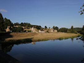 A landscape with houses and ruins by the water at Cosy Cocoon Malton