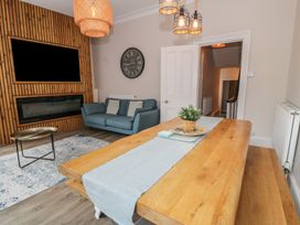 A living room with a sofa and dining table at Llety Cllyd in Barmouth