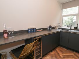 A kitchen with storage cupboards and a sink at Llety Cllyd in Barmouth