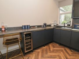 A kitchen with wine glasses and a bottle on the counter at Llety Cllyd Barmouth