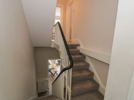A staircase with a handrail and doorway at Llety Cllyd in Barmouth