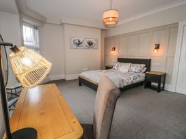 A bedroom with a bed, desk, and lamp at Llety Cllyd in Barmouth