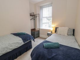 A bedroom with two beds and a nightstand at Llety Cllyd in Barmouth