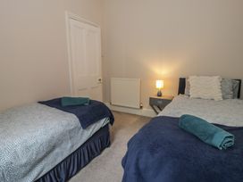 A bedroom with two beds and a bedside table at Llety Cllyd in Barmouth