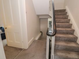 A staircase with carpet and a door at Llety Cllyd Barmouth