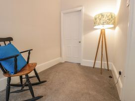 A snug with a rocking chair and floor lamp at Llety Cllyd in Barmouth