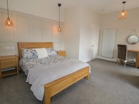 A bedroom with a bed, nightstand, desk and chair at Llety Cllyd in Barmouth