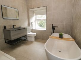 A bathroom with a bathtub, toilet, and vanity at Llety Cllyd in Barmouth