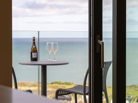A balcony with a table and wine glasses at Clifftop House Hot Tub in St Ives