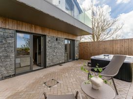 A patio with a hot tub and chairs at Clifftop House Hot Tub in St Ives