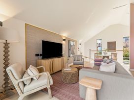 A living room with a television, sofa and armchair at Clifftop House Hot Tub, St Ives