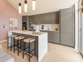 A kitchen with stools and cabinets at Clifftop House Hot Tub St Ives