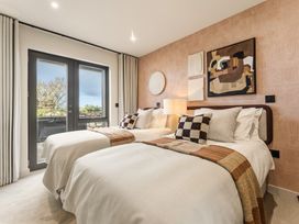 A bedroom with two beds and artwork at Clifftop House Hot Tub St Ives