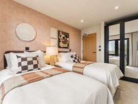 A bedroom with two beds and artwork on the wall at Clifftop House Hot Tub, St Ives