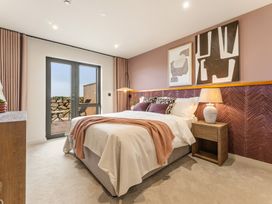 A bedroom with a bed and side table at Clifftop House Hot Tub in St Ives