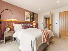 A bedroom with a bed and a lamp at Clifftop House Hot Tub in St Ives
