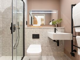 A bathroom with a shower, toilet, and sink at Clifftop House Hot Tub in St Ives