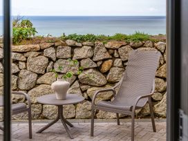An outdoor patio with a table and chairs at Clifftop House Hot Tub in St Ives
