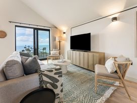 A living room with a sofa, coffee table, and television at tbc in St. Ives