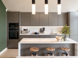 A kitchen with a bar counter and stools at tbc in St. Ives