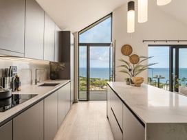 A kitchen with modern cabinets and an ocean view at tbc in St. Ives