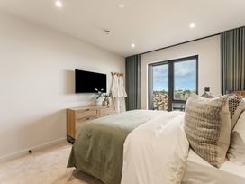 A bedroom with a bed, dresser and TV at tbc in St. Ives