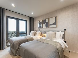 A bedroom with two beds and decorative wall art at tbc in St. Ives