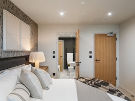 A bedroom with a bed and an adjoining bathroom at tbc St. Ives