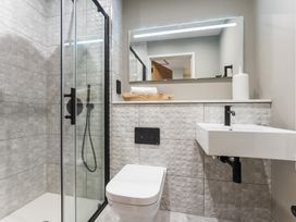 A bathroom with a glass shower, toilet, and sink at tbc in St. Ives