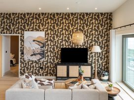 A living room with a sofa, coffee table, and television stand at tbc in St. Ives