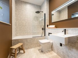 A bathroom with a bath tub, shower, toilet, and sink at tbc in St. Ives