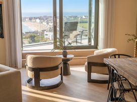 A living room with a window and chairs at Hidden 9 – Grand Bay Suite Hot Tub in St Ive