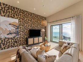 A living room with a sofa and television at Hidden 9 – Grand Bay Suite Hot Tub, St Ive