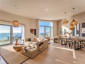 A living room with a sofa and dining table at Hidden 9 – Grand Bay Suite Hot Tub St Ive