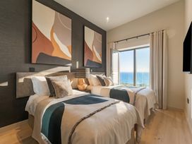 A bedroom with two beds and a view at Hidden 9 – Grand Bay Suite Hot Tub St Ive