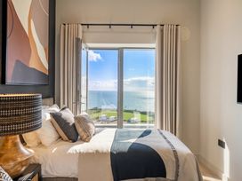 A bedroom with a bed and a view of the ocean at Hidden 9 – Grand Bay Suite Hot Tub St Ive