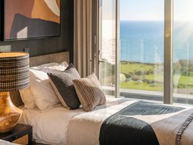 A bedroom with a bed and seaside view at Hidden 9 – Grand Bay Suite Hot Tub, St Ive
