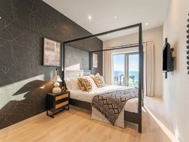 A bedroom with a bed and television at Hidden 9 – Grand Bay Suite Hot Tub St Ive