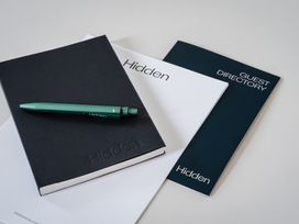 A notebook, pen, and guest directory on a table at Hidden 9- Grand Bay Suite Hot Tub St Ive