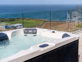 A hot tub with water and a sea view at tbc St. Ives